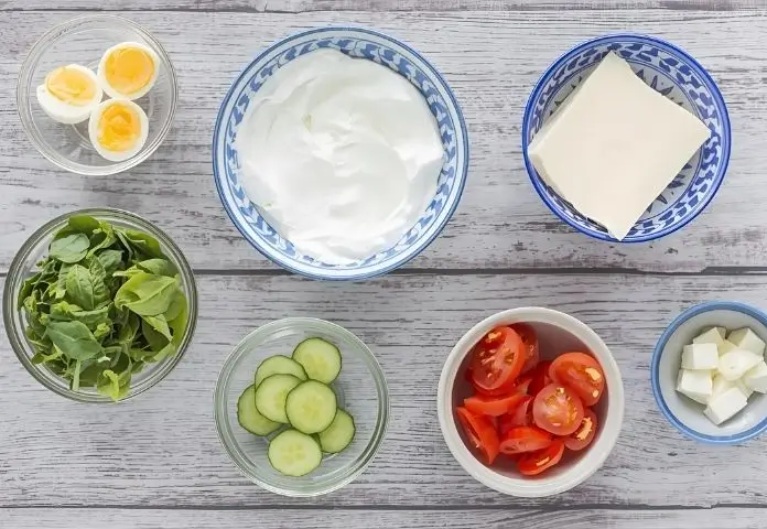 High protein sandwich ingredients including whole grain bread, grilled chicken, Greek yogurt, cheese, spinach, tomato, and cucumber slices.