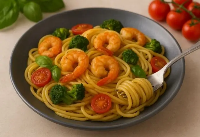 A colorful plate of shrimp and broccoli pasta topped with fresh basil and lemon zest, accompanied by toasted garlic bread and a fresh mixed green salad.